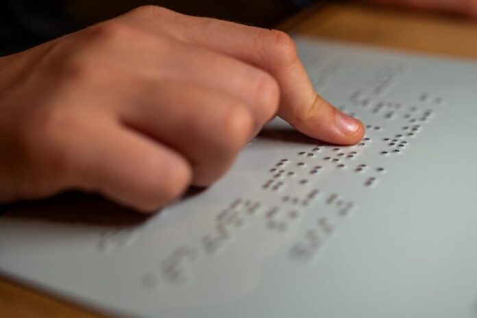Pessoa lê texto em braille