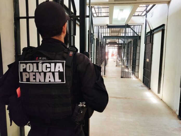 Um polícia protege a entrada de uma ala num presídio