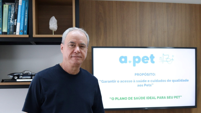 APET (5) Luiz Gênova, CEO da APet, em ambiente corporativo, com painel institucional da empresa ao fundo destacando o propósito de garantir saúde de qualidade aos pets