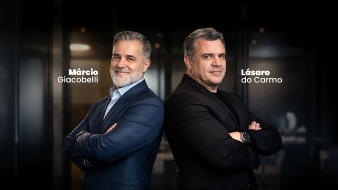 Marcio Giacobelli e Lásaro do Carmo Jr. posam lado a lado, de braços cruzados, em ambiente corporativo, representando liderança e tomada de decisão estratégica