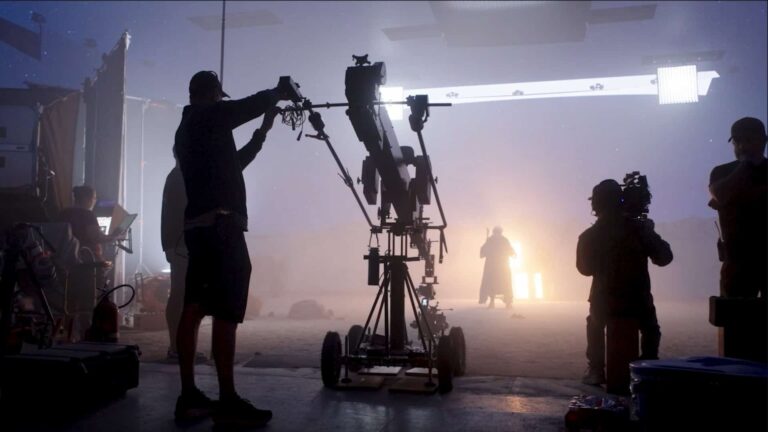 Técnico ajusta equipamento de câmera em estúdio de filmagem envolto em névoa
