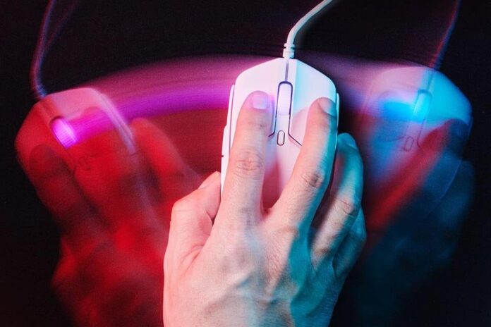 pessoa-usando-o-mouse-HyperX-Pulsefire-Haste-2-sobre-uma-bancada-escura-com-rastros-estilizados-coloridos-simulando-a-movimentação-do-mouse