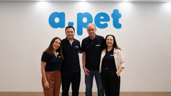 aPET (7) Equipe da APet reunida na sede da empresa, diante da identidade visual da marca.